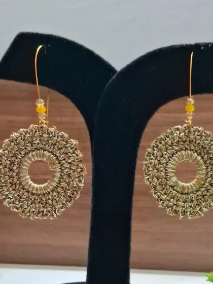 Golden-hued crochet hoop earrings with delicate bead detailing. These earrings add a touch of subtle sparkle and are versatile enough to pair with any outfit.