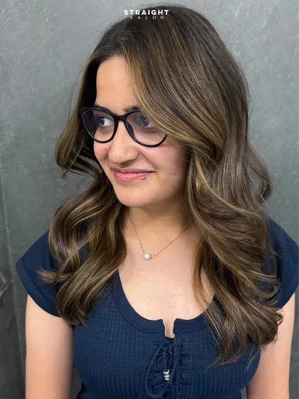 It's all about the confidence that comes with a fresh look. Here, I added soft, face-framing highlights and styled them into gentle waves to brighten her features.