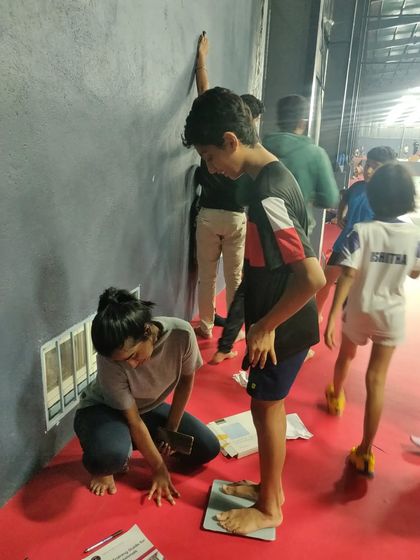 Ensuring we get accurate measurements is important. Here, I'm checking a young athlete's weight as part of our regular fitness assessment protocol.
