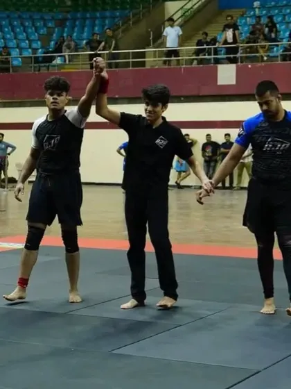 The referee raises our fighter's hand in victory. A moment of triumph after a tough battle on the competition mats.