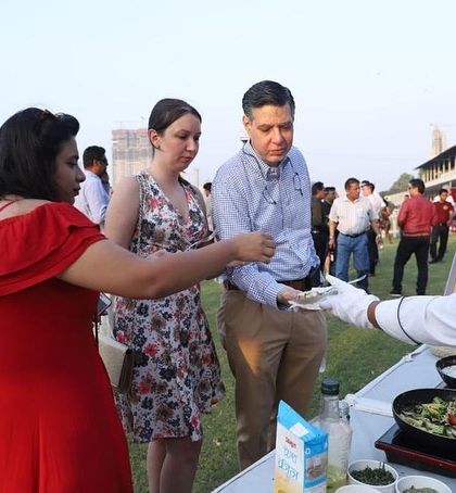 Our chef serving a freshly prepared plate of pasta to a guest at the Mahalaxmi Racecourse. We focus on providing professional and warm service at all our events.