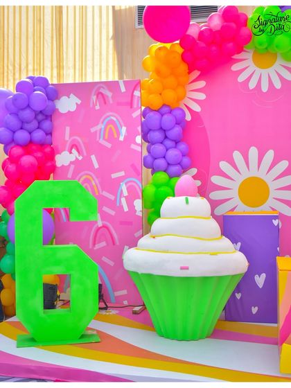 A close-up of the large-scale props, including a giant green number '6' and an oversized cupcake statue. These elements are always a hit with kids and look great in photos.