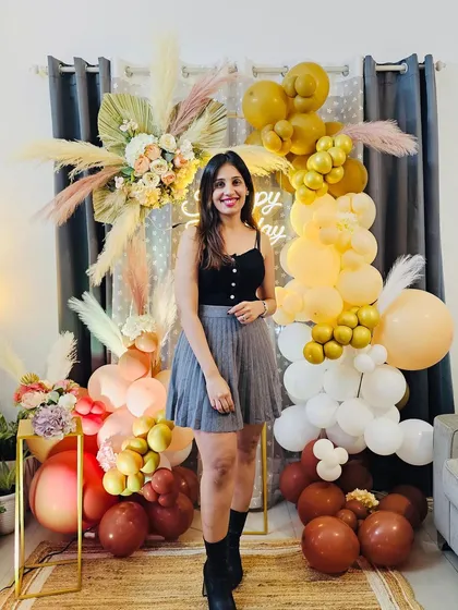 A happy client makes all the hard work worth it. Here she is, posing in front of her boho-inspired birthday decor, complete with pampas grass, a custom neon sign, and a multi-toned balloon garland. Seeing this smile is why I love what I do.
