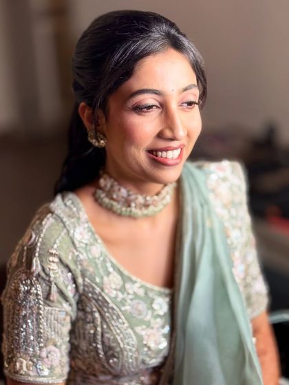 This side profile shows the soft contouring and the elegant half-up hairstyle we chose for her reception. The look is polished and sophisticated.