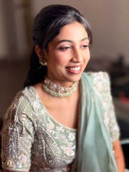 This side profile shows the soft contouring and the elegant half-up hairstyle we chose for her reception. The look is polished and sophisticated.