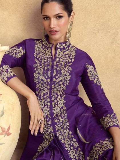 Feel like royalty in this violet premium silk palazzo suit. The intricate thread embroidery on the jacket-style top gives it a majestic look, perfect for a wedding or formal event.