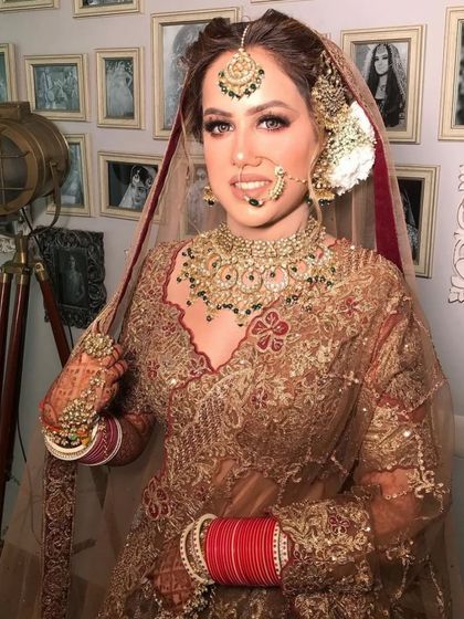 A classic bridal look with a heavy polki and green bead choker, paired with a passa and nath.