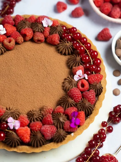 Handcrafted just for raspberry lovers. This tart features a crumbly biscuit base, house-made raspberry compote, and a luscious milk chocolate filling, all topped with fresh raspberries and red currants.