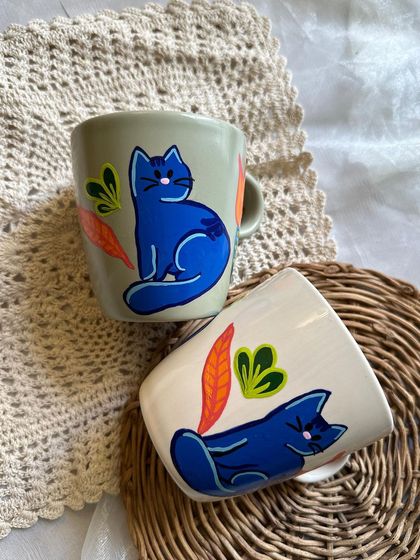 Our "Blue Cuddles" cat mug is now available on an off-white base, which really makes the vibrant blue of the cat pop.