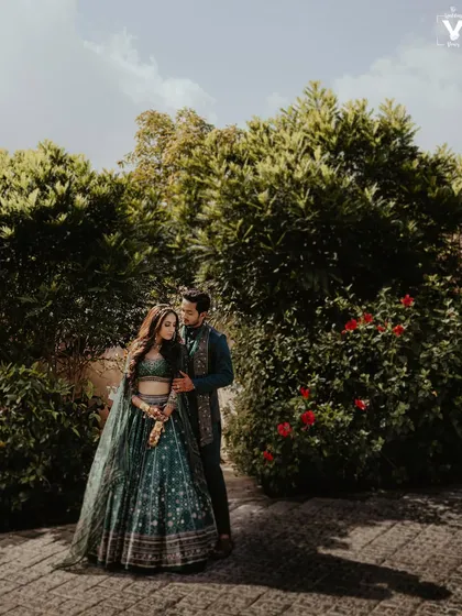 A stunning portrait of the couple in a garden at The Ananta Udaipur. The natural light and lush green surroundings create a serene and romantic atmosphere.