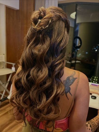 A side angle of the twisted half-up bun, highlighting the texture and the elegant gold accessory.