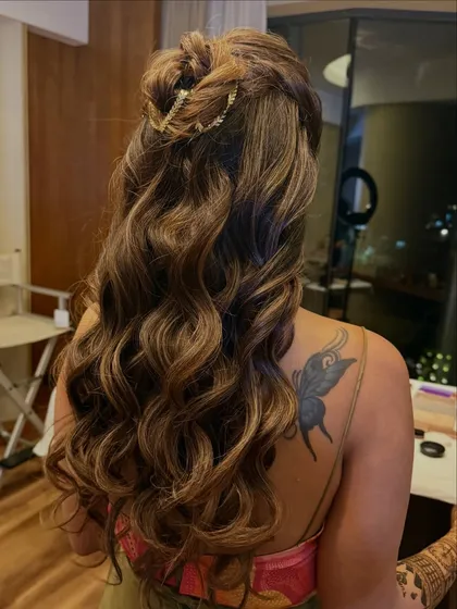 A side angle of the twisted half-up bun, highlighting the texture and the elegant gold accessory.