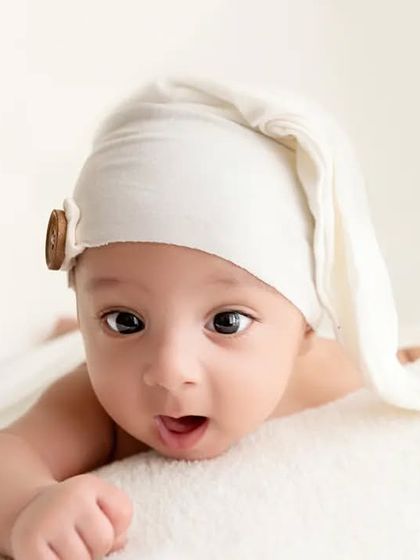 A baby with a surprised expression during his tummy time portrait session.