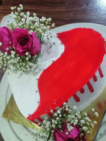 This romantic heart-shaped cake combines a glossy red drip with delicate fresh flowers. It's a beautiful choice for anniversaries, proposals, or any celebration of love.