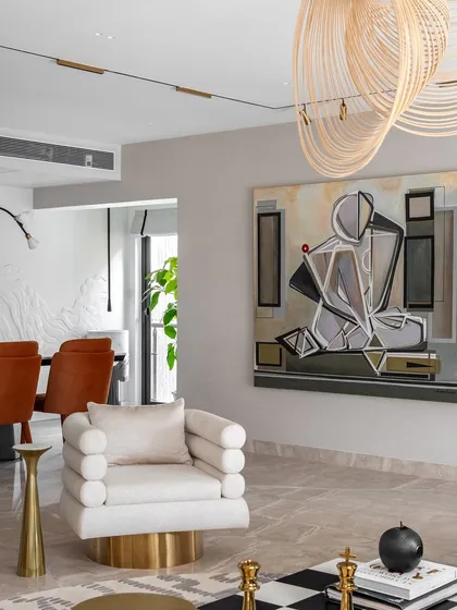 This shot captures the artistic details of the Evelyn living room. A custom abstract painting by my mother hangs above a unique tube-style armchair, with the checkered coffee table adding a graphic element. Every piece is chosen to contribute to the room's narrative.
