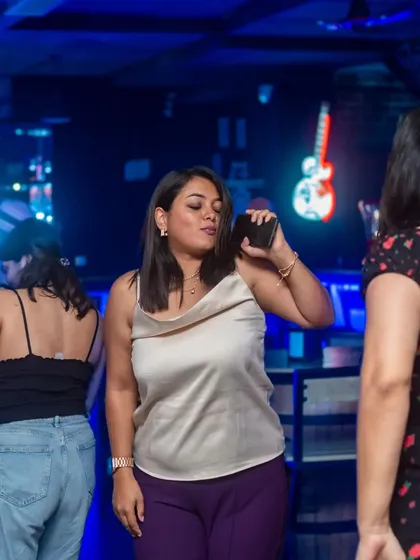 A guest enjoying the music, phone in hand, ready to capture a memory or request a song.