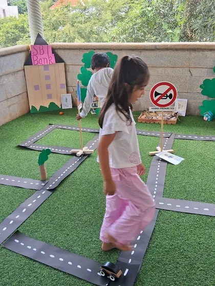 Imagination takes center stage in our miniature community role-play area. Children explore real-world concepts like road safety and community roles by driving toy cars through a town they helped create, turning abstract ideas into tangible fun.