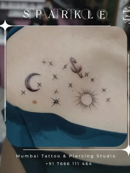 A celestial collection of sun, moon, planet, and stars tattooed on the shoulder. This piece demonstrates our skill in arranging multiple small elements into a cohesive and sparkling design.
