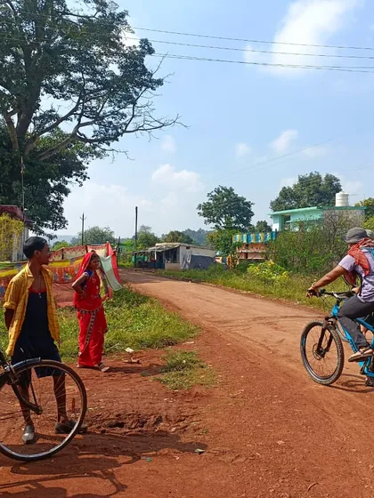 A guide cycles through a Baiga tribal village. Our tours are about more than just riding; they are about respectfully experiencing the culture and daily rhythms of the communities we visit.