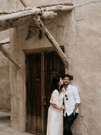 A sweet kiss on the cheek against the rustic, traditional architecture of Old Dubai.