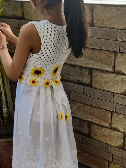 My daughter, my biggest inspiration, wearing her custom sunflower frock. Seeing her twirl in something I made just for her is the purest joy. This piece combines a light, airy dress with a hand-crocheted sunflower bodice and belt, perfect for special occasions or just feeling like a princess.