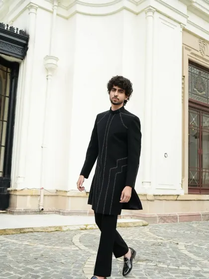 A minimalist black indowestern jacket with subtle stitched line details. This is for the man who appreciates understated elegance and sharp tailoring.