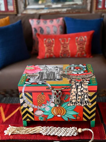Infused with a nomadic spirit, this Banjara-inspired accent trunk brings drama and color to any room. I use a collage of vintage portraits, oversized Afghan jewelry motifs, and bold patterns to turn a simple teak box into a vibrant, eclectic piece of functional art.
