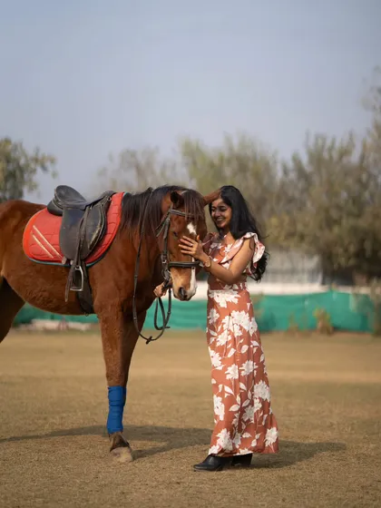 A full-body shot showing the scale and beauty of the horse next to the model.