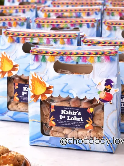 A closer look at the personalized Lohri gift bags, showing the colorful tassel border and festive bonfire graphic.