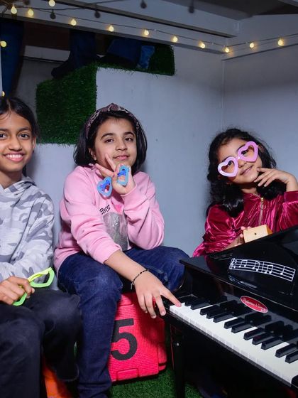 A jam session with friends! Our toy piano and fun props like heart-shaped glasses make for a great rockstar photo op.