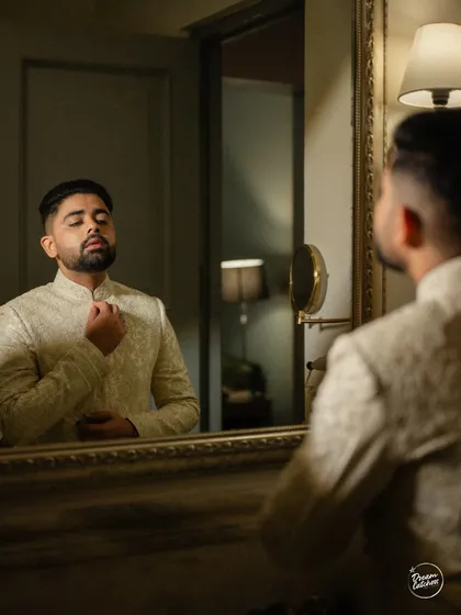 The groom getting ready, a classic shot of the final touches in front of the mirror.