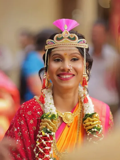 A beautiful, happy bride on her wedding day. Her look is completed with the traditional 'bashing' or 'mundavalya', a key element of the Maharashtrian ceremony.