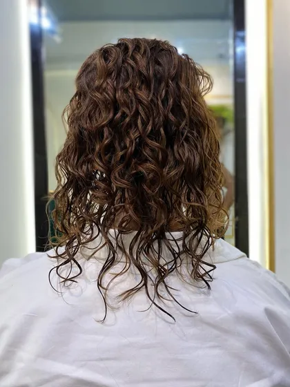 Another view of the client's hair before styling. Having healthy, hydrated curls is the key to making any updo look its best, as it ensures the hair is pliable and has a beautiful natural sheen.