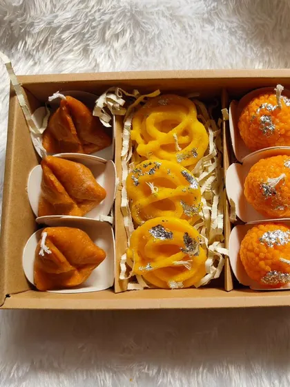 My food-inspired candles are always a conversation starter. This gift box features soy wax candles shaped like popular Indian sweets: samosas, jalebis, and motichoor ladoos, complete with silver leaf details.