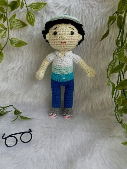 This handsome little boy replica doll features curly hair, a cap, and removable glasses. It’s so fun to create these little details that make each doll a true mini-me.