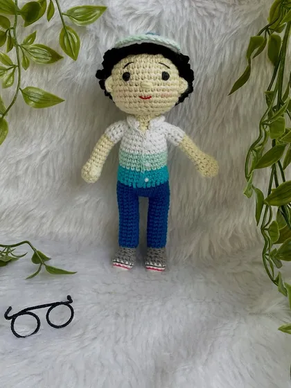 This handsome little boy replica doll features curly hair, a cap, and removable glasses. It’s so fun to create these little details that make each doll a true mini-me.
