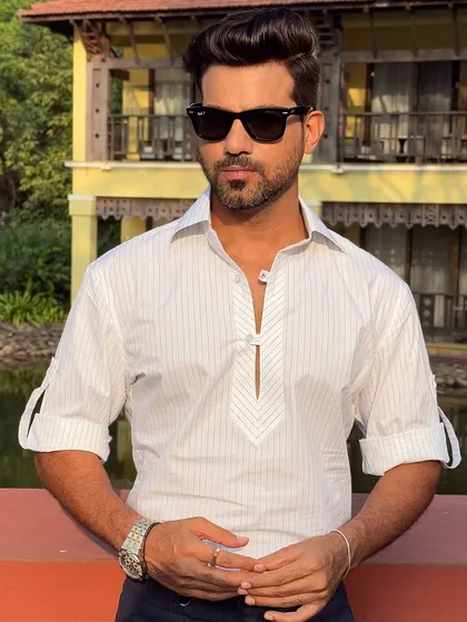 A closer look at the unique striped placket and cuff details, which add a touch of sophistication to this oversized white shirt.