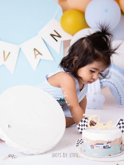 A car themed cake smash for a little racer. This little one seems more interested in dismantling the cake stand than the cake itself, which makes for a hilarious and authentic photo.