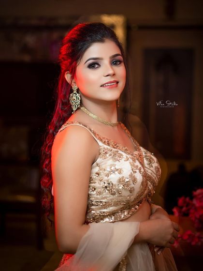 A confident and glamorous bridal portrait. The bride's direct gaze and the dramatic lighting create a powerful and striking image.