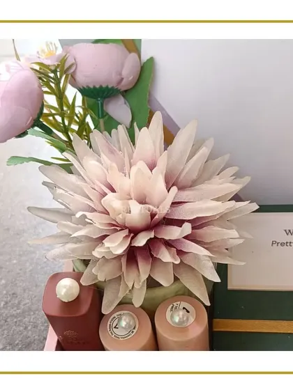A detailed shot of the floral decoration and the small, elegant nail polish bottles included in the engagement hamper.