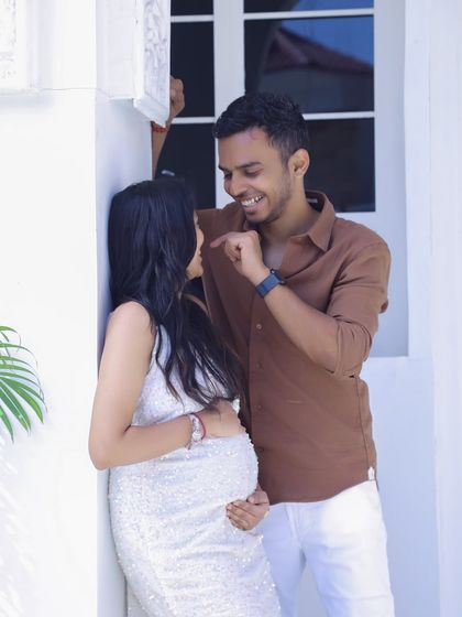A candid and happy moment between an expecting couple. This bright, high-key shot captures a natural interaction, perfect for a modern and relaxed maternity session.