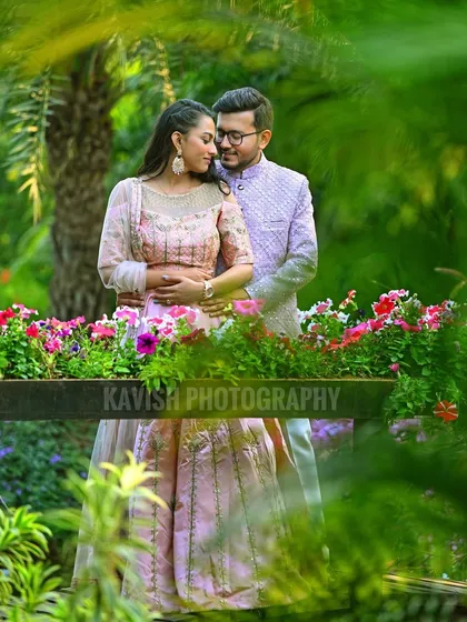 An intimate pre-wedding portrait of a couple surrounded by colorful flowers and lush greenery, creating a vibrant and romantic garden scene.