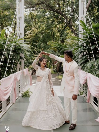 A playful moment as the groom twirls his bride on a bridge at their engagement shoot.