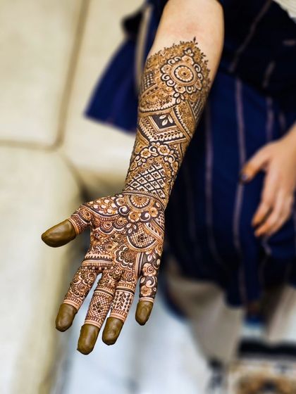 A single arm shot of an intricate engagement henna design.