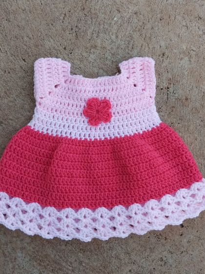 A classic baby frock in shades of pink. I designed this with a simple bodice, a flared skirt, and a delicate scalloped hem. It's a timeless piece that's perfect for any baby girl.