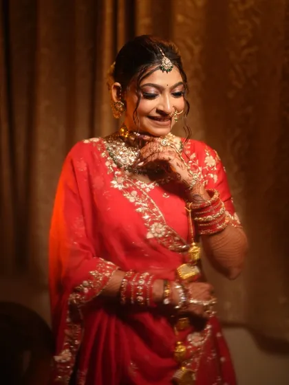 The bride adjusting her nose ring, a classic and graceful pose.