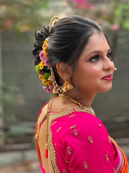 A side profile showing the intricate details of her floral hairstyle and traditional earrings.