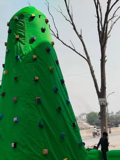 Another shot of the green climbing wall, showing its height against the trees. It's a safe way to introduce kids to rock climbing.
