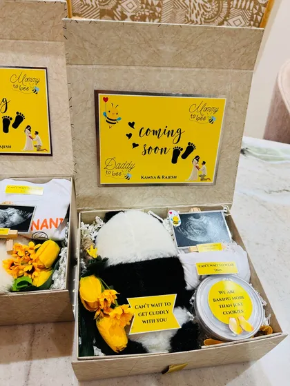 A close-up of one of the reveal boxes, featuring a cuddly panda, a personalized onesie, and the baby's first ultrasound picture.