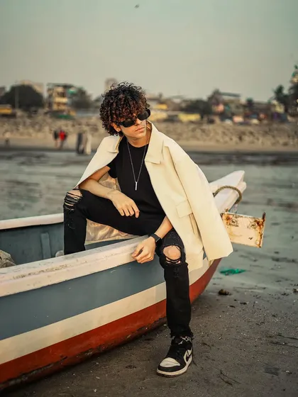 An edgy men's fashion shoot on the beach, using a boat as a prop. This combines a rugged location with a stylish look for a unique portfolio image.